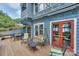Spacious deck with outdoor seating, porch swing, and serene lake views through the red doors at 405 Northwest Dr, Davidson, NC 28036