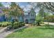 Charming blue home surrounded by lush landscaping, and inviting walkway at 405 Northwest Dr, Davidson, NC 28036