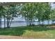 Picturesque lake view framed by lush trees and a well maintained lawn at 405 Northwest Dr, Davidson, NC 28036