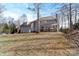 Rear view of house with a view of the covered back porch and treed backyard at 4915 Ardenwoods Dr, Charlotte, NC 28215