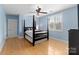 The bedroom has a hardwood floor, a ceiling fan, a dark wood bed, and a window with shutters at 4915 Ardenwoods Dr, Charlotte, NC 28215