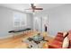 Living room with hardwood floors, ceiling fan, glass coffee table, and a red sofa at 4915 Ardenwoods Dr, Charlotte, NC 28215
