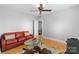 Living room with hardwood floors, ceiling fan, glass coffee table, and red sofa at 4915 Ardenwoods Dr, Charlotte, NC 28215