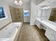 Bright bathroom with a soaking tub, separate glass-enclosed shower, and double vanity sink at 6409 Chadwell Ct, Fort Mill, SC 29707