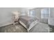 Well-lit bedroom with a striped bedspread, nightstand, and windows at 730 Bonica Ct, Lancaster, SC 29720