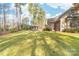 Expansive backyard showcasing mature trees and a covered patio area for entertaining at 7674 Bermuda Hills Ln, Denver, NC 28037