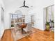 Bright breakfast nook with hardwood floors, a ceiling fan, and large windows overlooking the landscaped yard at 7674 Bermuda Hills Ln, Denver, NC 28037