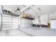 Spacious three car garage with lots of space, storage overhead, and a white refrigerator in the back at 7674 Bermuda Hills Ln, Denver, NC 28037