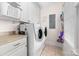 Clean laundry room with storage, counter space, modern washer and dryer, and tile floors at 7674 Bermuda Hills Ln, Denver, NC 28037