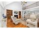 Spacious living room with fireplace, built-in bookshelves, hardwood floors, and tall ceilings with a fan at 7674 Bermuda Hills Ln, Denver, NC 28037