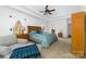 Spacious main bedroom with tray ceiling, hardwood floors, accent chair, and plenty of natural light at 7674 Bermuda Hills Ln, Denver, NC 28037