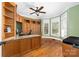 Home office with built-in desk, cabinets, hardwood floors, and a large window with a view at 7674 Bermuda Hills Ln, Denver, NC 28037