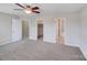 Neutral bedroom featuring gray carpet, ceiling fan, and two open doorway access points at 8007 Shadbrush Ct, Charlotte, NC 28215