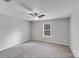 Neutral bedroom featuring gray carpet, a window, and a ceiling fan with lighting at 8007 Shadbrush Ct, Charlotte, NC 28215