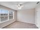 Bright, neutral bedroom featuring carpeted floor, a ceiling fan, and large window at 8007 Shadbrush Ct, Charlotte, NC 28215