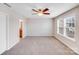 Spacious bedroom featuring plush carpet, neutral walls, and a modern ceiling fan at 8007 Shadbrush Ct, Charlotte, NC 28215