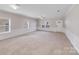 Bright living room featuring a ceiling fan, neutral walls, white trim and wainscoting at 8007 Shadbrush Ct, Charlotte, NC 28215