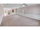 Spacious open-concept living room with neutral carpet, wainscoting, and plenty of natural light at 8007 Shadbrush Ct, Charlotte, NC 28215