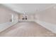 Bright living room featuring a ceiling fan, neutral walls, white trim and wainscoting at 8007 Shadbrush Ct, Charlotte, NC 28215