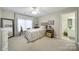 Cozy bedroom with natural light, a sitting bench, and access to a full bathroom at 907 Thorn Ridge Ln, Lake Wylie, SC 29710
