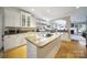 Bright kitchen featuring granite countertops, a central island with cooktop, and white cabinetry at 907 Thorn Ridge Ln, Lake Wylie, SC 29710