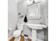 This bathroom includes wood flooring, pedestal sink, decorative mirror, and a toilet, complemented by stylish wall decor at 907 Thorn Ridge Ln, Lake Wylie, SC 29710