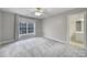 Bedroom with neutral walls, carpet flooring, large window letting in natural light, and an adjacent bathroom at 907 Thorn Ridge Ln, Lake Wylie, SC 29710