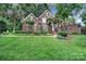 Beautiful two-story brick home with lush landscaping, a well-manicured lawn, and mature trees at 907 Thorn Ridge Ln, Lake Wylie, SC 29710