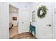 Welcoming hallway featuring a decorative wreath, modern table, and an entryway to a bedroom with a four poster bed at 9119 Gander Dr, Charlotte, NC 28277