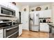 Bright kitchen featuring stainless steel appliances, white cabinetry, and hardwood floors at 9119 Gander Dr, Charlotte, NC 28277