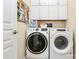 Laundry room features a front load washer and dryer with white storage cabinets above at 9119 Gander Dr, Charlotte, NC 28277