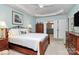 Serene main bedroom with tray ceilings, a wrought iron bed frame, and a glimpse into the ensuite bathroom at 9119 Gander Dr, Charlotte, NC 28277