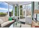 Screened porch with wicker furniture, glass coffee table, ceiling fan and green and white drapes at 9119 Gander Dr, Charlotte, NC 28277