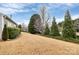 Wide shot of side yard featuring mature trees, landscaping, and an expansive lawn at 9119 Gander Dr, Charlotte, NC 28277