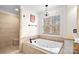 Bright bathroom featuring a soaking tub under a window and a tiled walk-in shower at 9135 Fair Oak Dr, Sherrills Ford, NC 28673