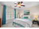 Cozy bedroom features a large window, ceiling fan, plush bedding, and a serene ambiance at 9135 Fair Oak Dr, Sherrills Ford, NC 28673