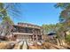 View of the back exterior, showcasing a screened-in porch, stone patio, attached garage, and private backyard at 9135 Fair Oak Dr, Sherrills Ford, NC 28673