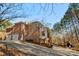 Rear exterior view of the home featuring a 2-car garage and outdoor fireplace in a wooded setting at 9135 Fair Oak Dr, Sherrills Ford, NC 28673