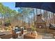 Cozy outdoor seating area with a stone fireplace in a wooded setting at 9135 Fair Oak Dr, Sherrills Ford, NC 28673