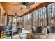 Spacious screened porch with wood ceiling, ceiling fans, a comfortable couch, and tranquil views of the wooded backyard at 9135 Fair Oak Dr, Sherrills Ford, NC 28673