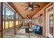 Cozy screened porch with wood ceiling, ceiling fans, a comfortable couch, and views of the lush backyard at 9135 Fair Oak Dr, Sherrills Ford, NC 28673