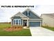 Charming home featuring a manicured lawn, a two-car garage, and a welcoming front porch at 103 Noah Ln, Troutman, NC 28166