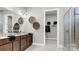 Elegant bathroom with double vanity sinks, a decorative mirror, and access to a walk-in closet and shower at 1043 Rabbit Hill Ln, Monroe, NC 28110