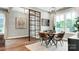 This dining area has a modern chandelier, a glass partition, and a table set for four near a bright window at 1043 Rabbit Hill Ln, Monroe, NC 28110