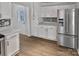 Bright kitchen featuring stainless refrigerator, white cabinets, and mosaic tile backsplash at 10906 Falls Branch Ln, Charlotte, NC 28214