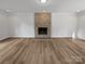 Bright living room featuring a stone fireplace, new flooring, and ample space at 10906 Falls Branch Ln, Charlotte, NC 28214