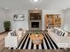 Stylishly staged living room with a stone fireplace, modern furniture, and striped rug at 10906 Falls Branch Ln, Charlotte, NC 28214