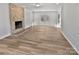 Bright living room featuring a stone fireplace, wood floors, and access to outdoor space at 10906 Falls Branch Ln, Charlotte, NC 28214