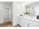 Modern bathroom featuring a double vanity, large mirror, and an open doorway to a walk-in closet at 111 Rustling Waters Dr, Mooresville, NC 28117