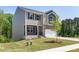 Two-story home shows light brown siding, a two-car garage, and a neatly kept lawn and sidewalk at 111 Rustling Waters Dr, Mooresville, NC 28117